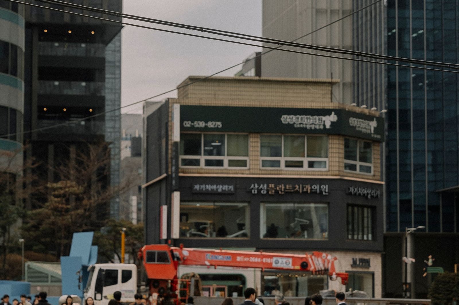 Office workers crossing a wide crosswalk between office towers in Seoul